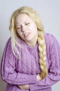 リーキーガット症候群で腹痛に苦しむ女性